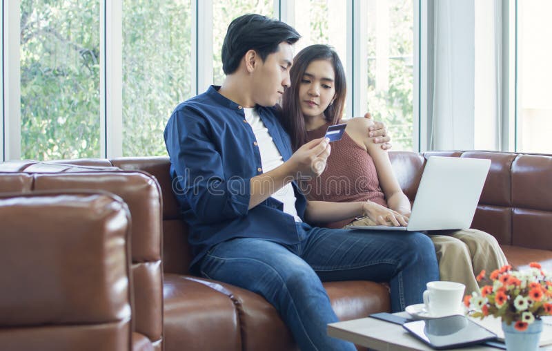 Una pareja está haciendo compras en línea en casa imágenes de archivo libres de regalías