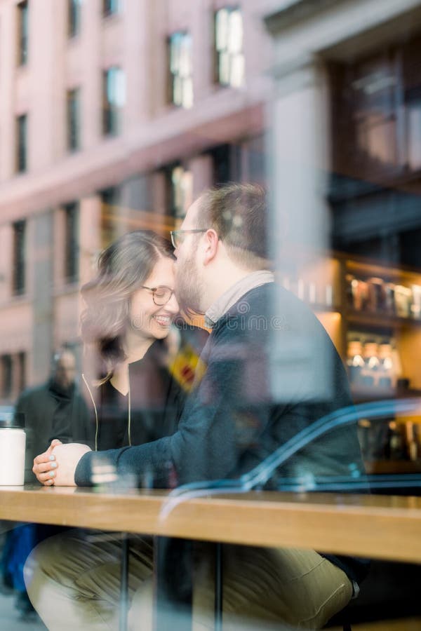 Una pareja joven heterosexual disfrutando de una conversación en una cafetería de nyc