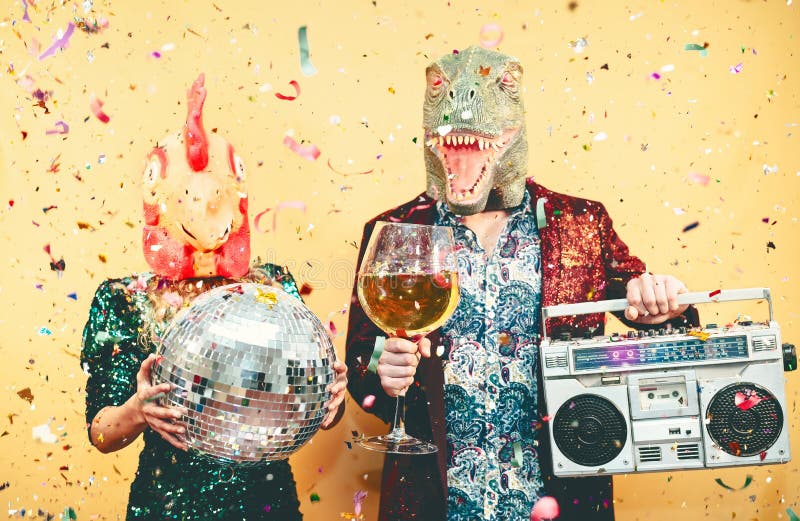 Una pareja loca celebra la víspera de Año Nuevo usando una máscara de rex de pollo y dinosaurio - Jóvenes de moda divirtiéndose t