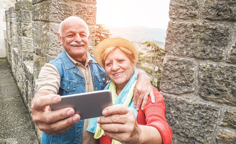 Una pareja mayor se toma un selfie dentro de un castillo en vacaciones turísticas - Maduro marido y mujer divirtiéndose con las t fotos de archivo Una pareja mayor se toma un selfie dentro de un castillo en vacaciones turísticas - Maduro marido y mujer divirtiéndose con las t fotos de archivo