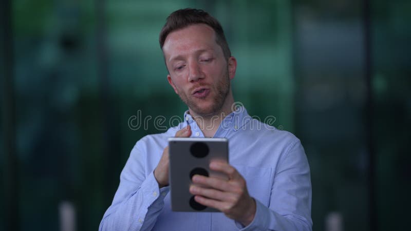 Una persona en una videollamada con una tablet que muestra interés y atención en la comunicación almacen de metraje de vídeo