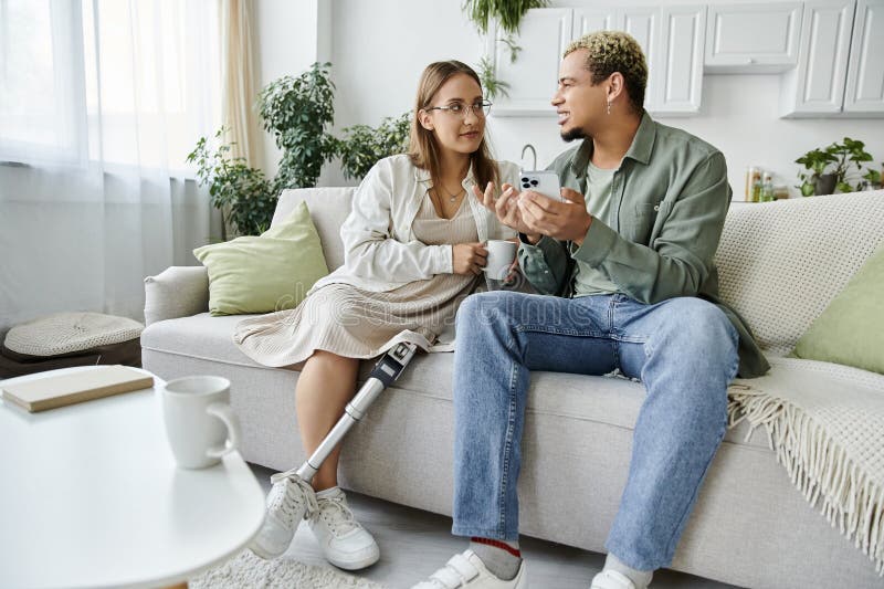 Una persona non binaria e un suo amico che conversano con calore nella home stock photo