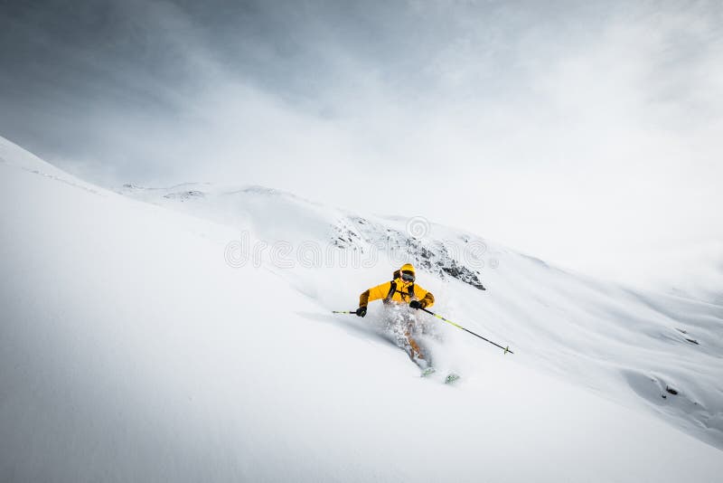 Una persona in rivestimento luminoso sta sciando in alte montagne Il Tirolo, Austria tempo soleggiato immagine stock libera da diritti Una persona in rivestimento luminoso sta sciando in alte montagne Il Tirolo, Austria tempo soleggiato immagine stock libera da diritti