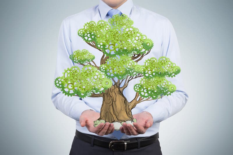 Una persona in vestiti convenzionali tiene un albero schizzato sulle palme immagine stock libera da diritti Una persona in vestiti convenzionali tiene un albero schizzato sulle palme immagine stock libera da diritti
