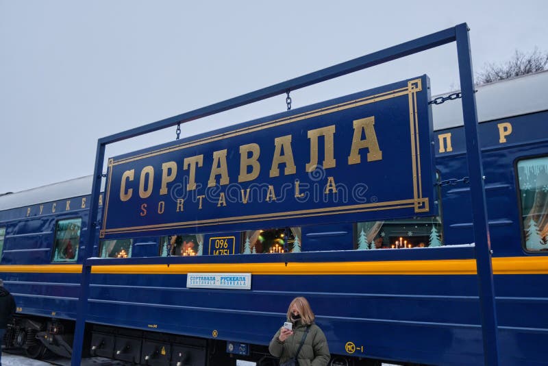 Una piastra con il nome della stazione di sortavala sulla piattaforma sullo sfondo del trasporto del treno retrorifloreale fotografie stock