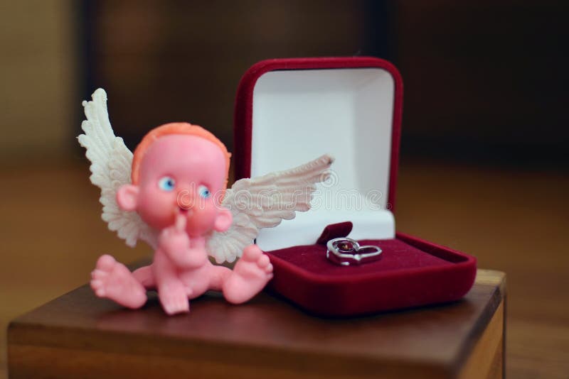 Una piccola figura di un angelo sfuocato che si siede su o vicino ad una fine del contenitore di gioielli su fotografie stock libere da diritti Una piccola figura di un angelo sfuocato che si siede su o vicino ad una fine del contenitore di gioielli su fotografie stock libere da diritti