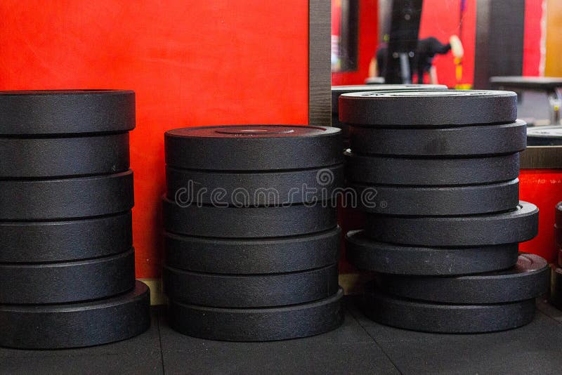 Una pila de pesos del disco del hierro en un gimnasio fotos de archivo libres de regalías Una pila de pesos del disco del hierro en un gimnasio fotos de archivo libres de regalías