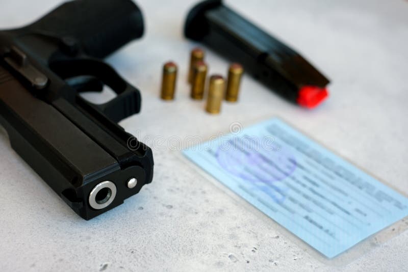 Una pistola con proiettili che simboleggiano i diritti delle armi mentre viene incastrata contro la Costituzione degli Stati Unit fotografie stock Una pistola con proiettili che simboleggiano i diritti delle armi mentre viene incastrata contro la Costituzione degli Stati Unit fotografie stock