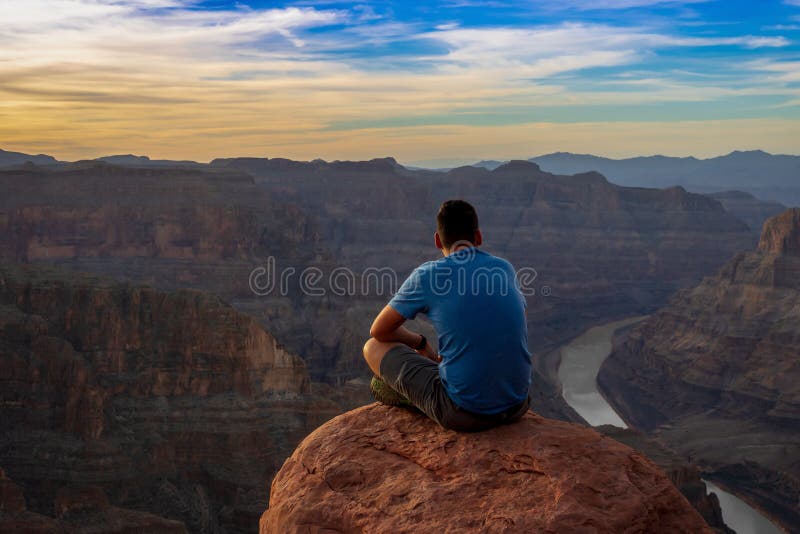Una puesta del sol de observación del hombre en Grand Canyon imagenes de archivo Una puesta del sol de observación del hombre en Grand Canyon imagenes de archivo