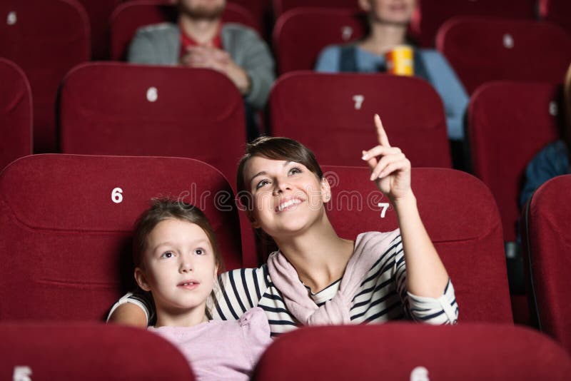 Una ragazza con la madre al cinematografo immagini stock libere da diritti Una ragazza con la madre al cinematografo immagini stock libere da diritti