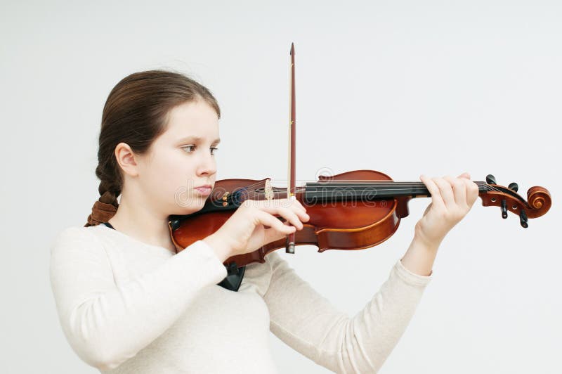 Una ragazza concentrata che gioca violino sopra fondo bianco fotografie stock libere da diritti Una ragazza concentrata che gioca violino sopra fondo bianco fotografie stock libere da diritti