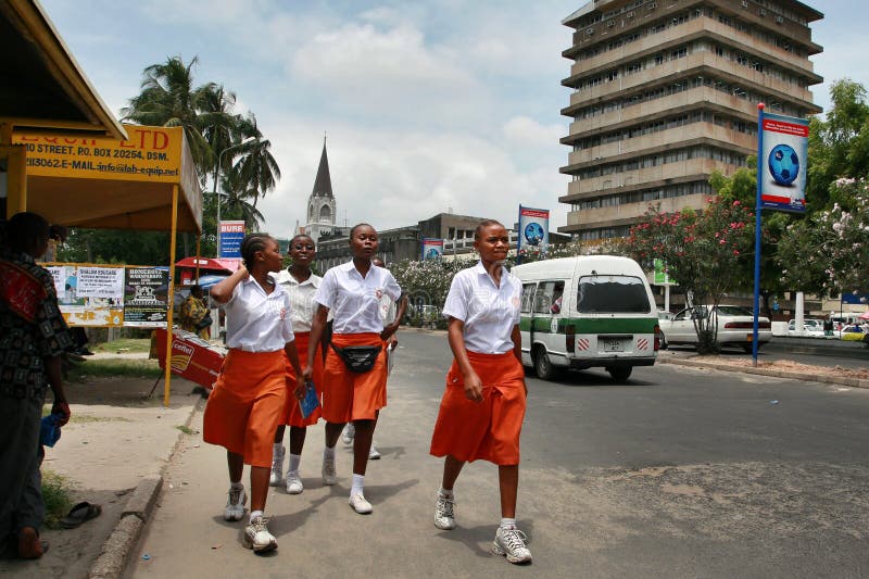 Una ragazza di quattro africani neri in gonne dell'arancia e bluse bianche fotografia stock libera da diritti Una ragazza di quattro africani neri in gonne dell'arancia e bluse bianche fotografia stock libera da diritti
