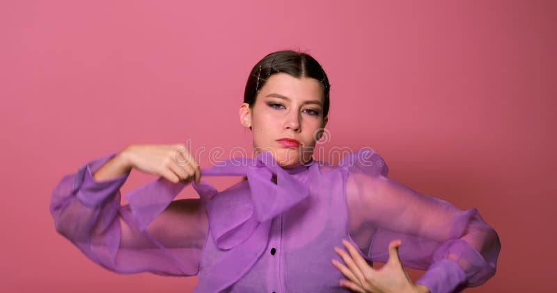 Una ragazza divertente che danza su sfondo rosa in studio