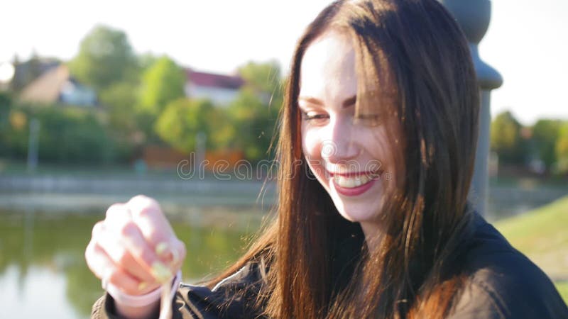 Una ragazza felice con capelli lunghi neri e labbra rosse beve caffè Nello stagno di fondo Chiudi ripresa