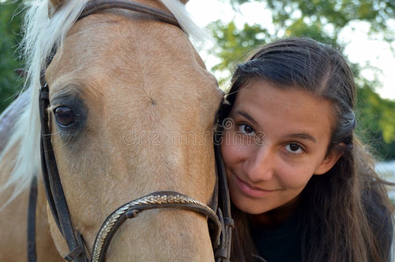 Una ragazza teenager con il suo cavallo immagini stock Una ragazza teenager con il suo cavallo immagini stock