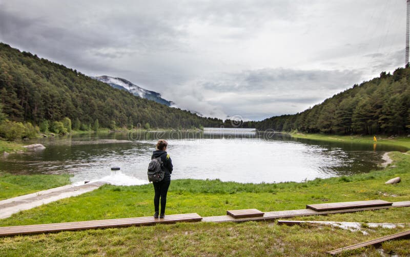 Una ragazza turistica in piedi accanto al lago Engolasters, durante un'escursione, nella parrocchia di Encamp di Andorra, Lago fo fotografia stock libera da diritti