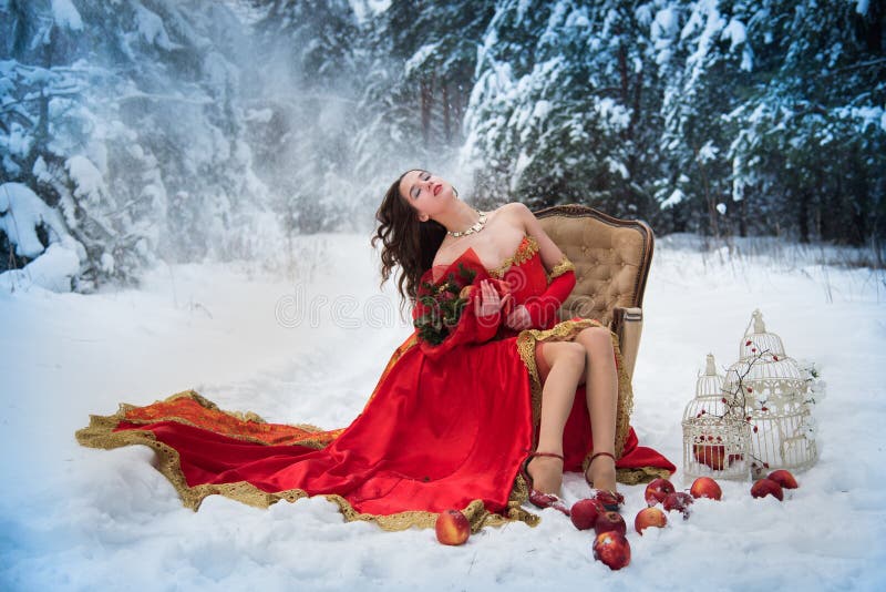 Una ragazza in un'immagine di fiaba di una regina posa in una foresta innevata dell'inverno immagini stock