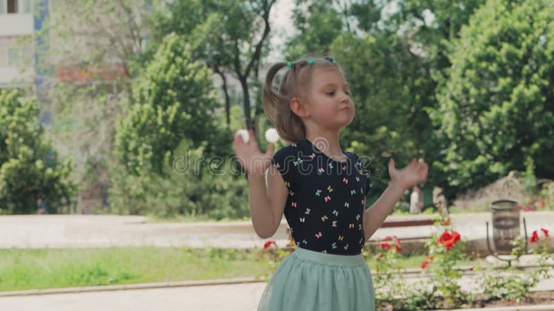 Una ragazzina che danza e salta nel parco cittadino.
