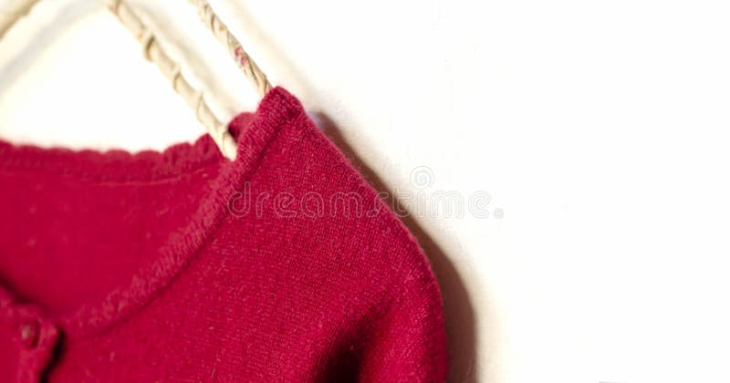 Una rebeca en la ejecución roja en la suspensión de ropa en el fondo blanco foto de archivo libre de regalías Una rebeca en la ejecución roja en la suspensión de ropa en el fondo blanco foto de archivo libre de regalías