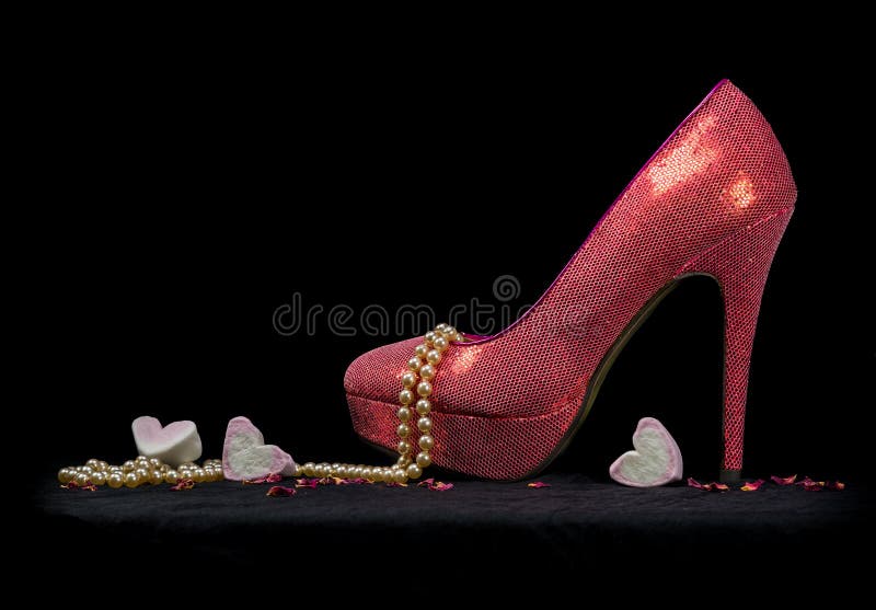 Una scarpa sexy, perle e cuori, fondo nero fotografie stock libere da diritti Una scarpa sexy, perle e cuori, fondo nero fotografie stock libere da diritti