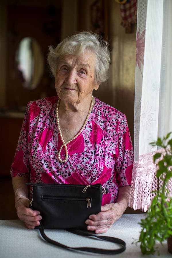 Una Señora Mayor Con Un Bolso Se Coloca En La Tabla Imagen de archivo - Imagen mayor, belleza: 119444995