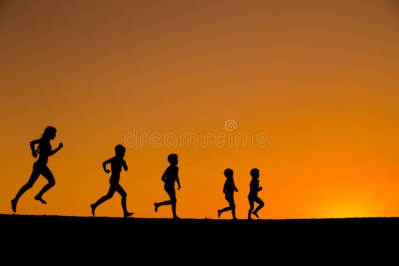 Una siluetta di cinque bambini correnti contro il tramonto immagini stock libere da diritti Una siluetta di cinque bambini correnti contro il tramonto immagini stock libere da diritti