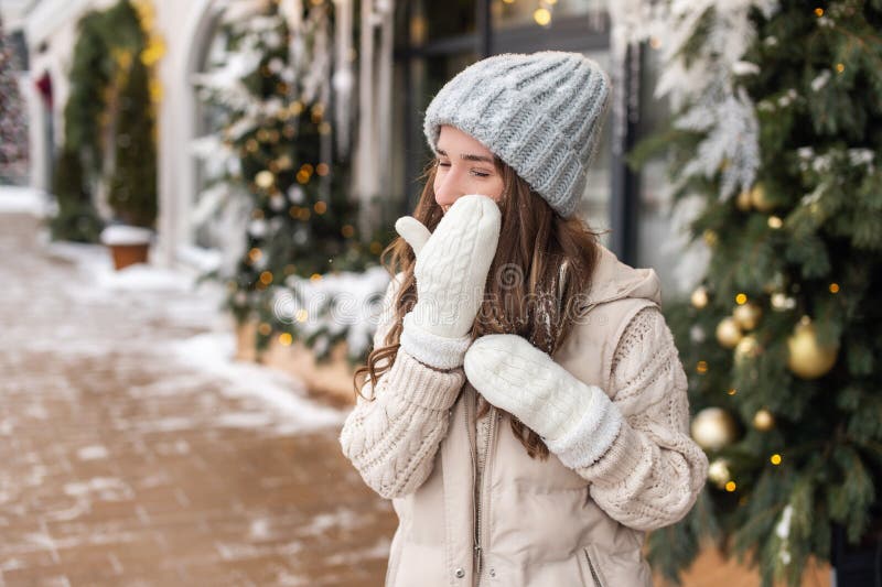 Una sonriente le quita la nieve de la cara con una migaja blanca fotos de archivo
