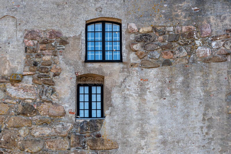 Una struttura orizzontale di due finestre su una vecchia parete di pietra medievale antica ruvida alla fortezza di Varberg in Sve fotografia stock libera da diritti Una struttura orizzontale di due finestre su una vecchia parete di pietra medievale antica ruvida alla fortezza di Varberg in Sve fotografia stock libera da diritti