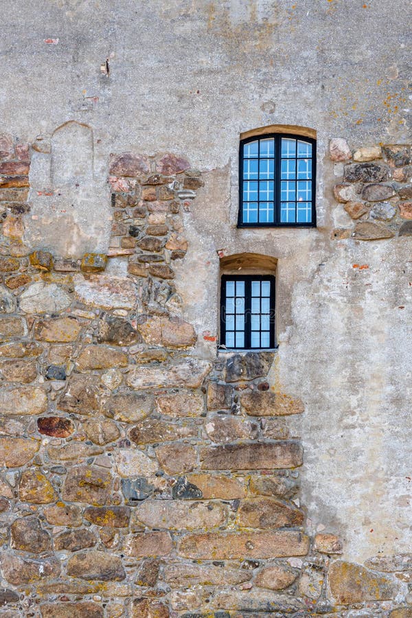 Una struttura verticale di due finestre su una vecchia parete di pietra medievale antica ruvida alla fortezza di Varberg in Svezi fotografia stock libera da diritti Una struttura verticale di due finestre su una vecchia parete di pietra medievale antica ruvida alla fortezza di Varberg in Svezi fotografia stock libera da diritti