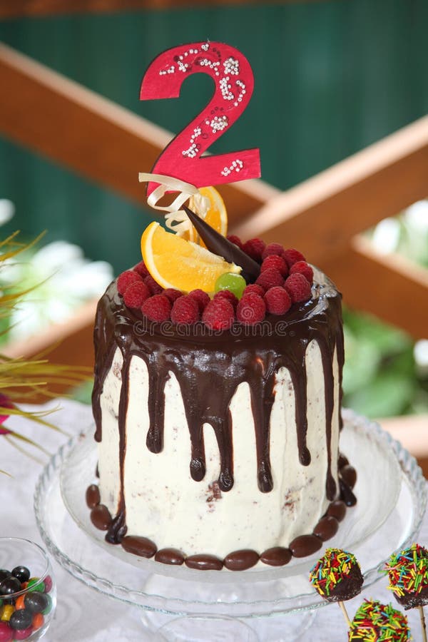 Una tavola festiva decorata con la torta di compleanno con i fiori ed i dolci fotografie stock Una tavola festiva decorata con la torta di compleanno con i fiori ed i dolci fotografie stock