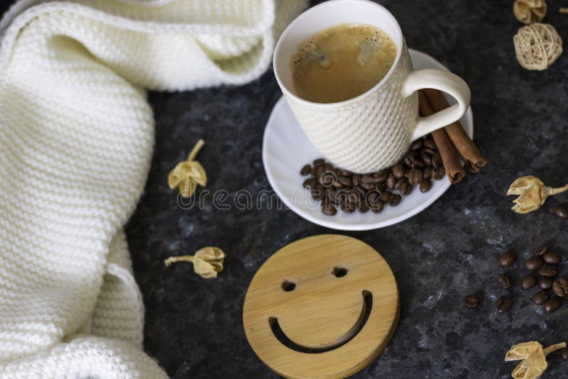Una taza de caf? es la llave a un buen humor Smiley de madera en un fondo oscuro, negro, de textura En la tabla hay un blanco, imagen de archivo Una taza de caf? es la llave a un buen humor Smiley de madera en un fondo oscuro, negro, de textura En la tabla hay un blanco, imagen de archivo