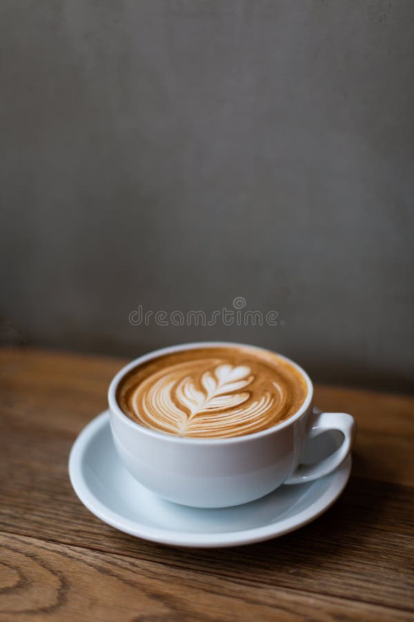 Una taza de capuchino con arte del latte imagenes de archivo Una taza de capuchino con arte del latte imagenes de archivo