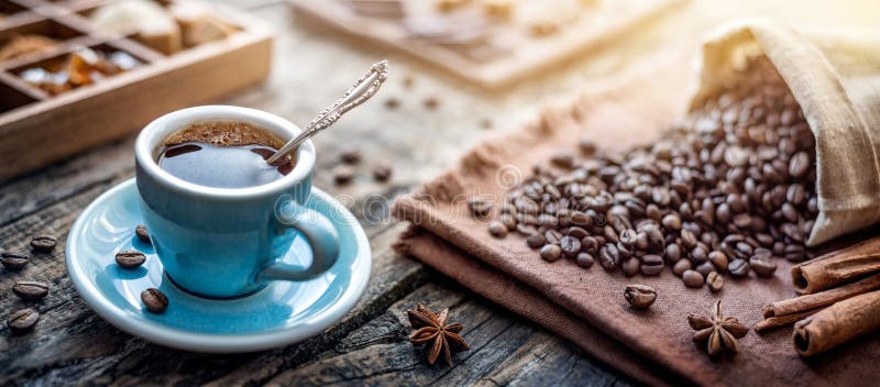Una tazza di caffè nero e fagioli di caffè sul tavolo. Espresso per colazione in una bellissima tazza blu fotografie stock
