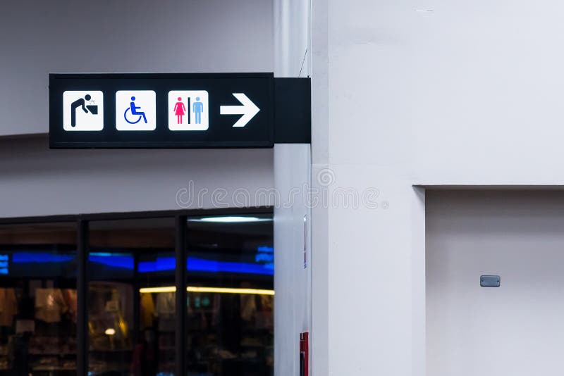 Una toilette pubblica con accesso disabile firma dentro il termina dell'aeroporto fotografia stock Una toilette pubblica con accesso disabile firma dentro il termina dell'aeroporto fotografia stock