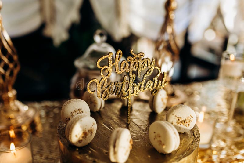 Una torta de cumplea?os de oro se adorna con macarrones imagenes de archivo Una torta de cumplea?os de oro se adorna con macarrones imagenes de archivo