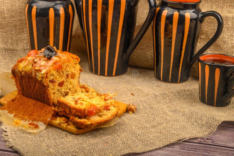 Una torta di Natale fatta in porzioni su una tavola di legno e su un tavolo in ceramica su un tavolo ricoperto di panno per la ca immagine stock Una torta di Natale fatta in porzioni su una tavola di legno e su un tavolo in ceramica su un tavolo ricoperto di panno per la ca immagine stock