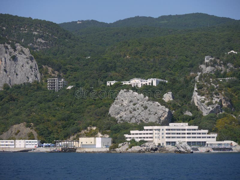 Una vista de las montañas crimeas y de los edificios blancos en el meollo del bosque foto de archivo libre de regalías Una vista de las montañas crimeas y de los edificios blancos en el meollo del bosque foto de archivo libre de regalías
