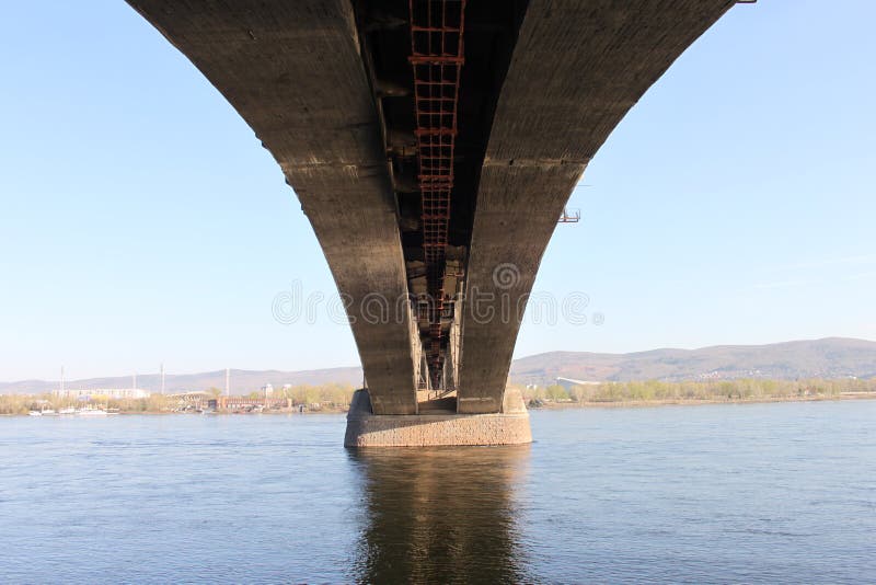 Una vista inferior del puente comunal a través del río Yenisey en un día soleado caliente en la ciudad de Krasnoyarsk en Rusia fotografía de archivo libre de regalías Una vista inferior del puente comunal a través del río Yenisey en un día soleado caliente en la ciudad de Krasnoyarsk en Rusia fotografía de archivo libre de regalías