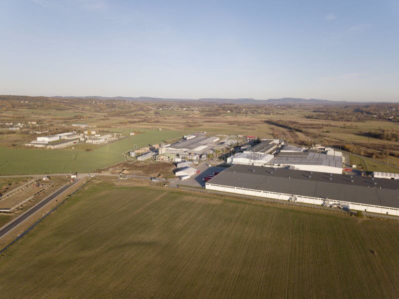Una vista panorámica de una fábrica situada entre campos verdes Fotografía aérea de una instalación industrial de un abejón o de imágenes de archivo libres de regalías Una vista panorámica de una fábrica situada entre campos verdes Fotografía aérea de una instalación industrial de un abejón o de imágenes de archivo libres de regalías