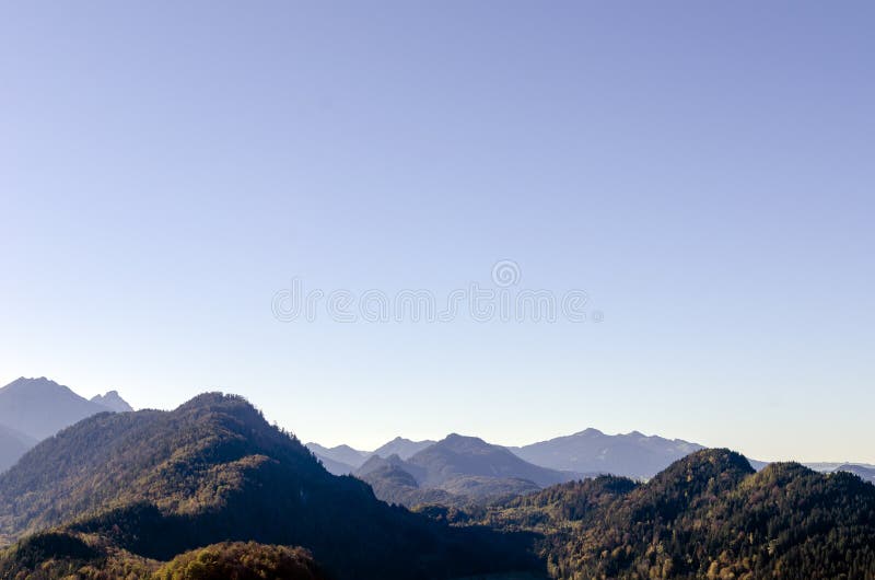 Una vista panorámica espaciosa de las montañas de las montañas cubiertas con los árboles coloridos en un día soleado de octubre c imagen de archivo libre de regalías Una vista panorámica espaciosa de las montañas de las montañas cubiertas con los árboles coloridos en un día soleado de octubre c imagen de archivo libre de regalías