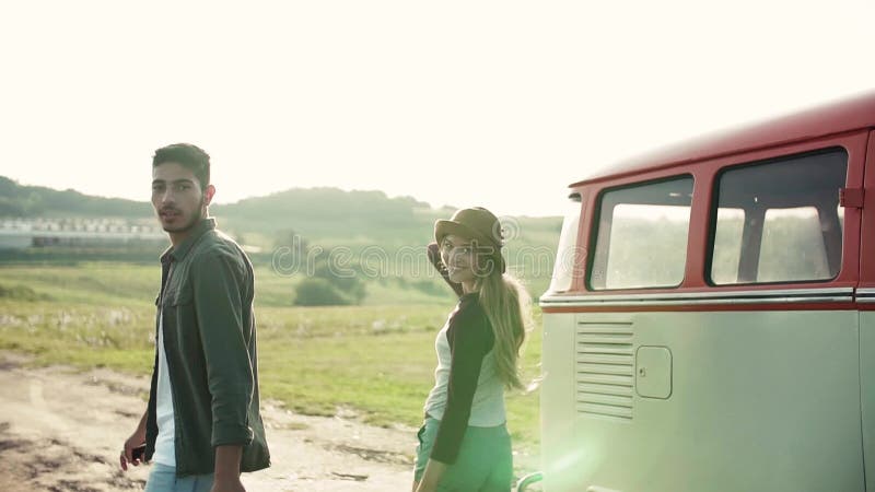 Una vista posterior de pares jovenes en un roadtrip a través del campo, caminando almacen de metraje de vídeo