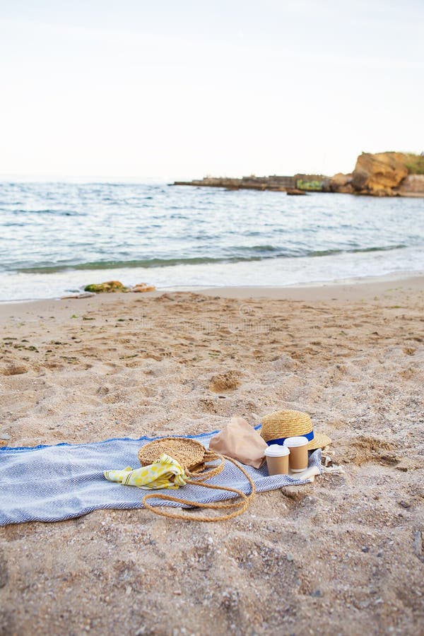 Una yegua azul sobre la que se ponen vasos de plástico con café, una bolsa, un sombrero a orillas del mar fotografía de archivo Una yegua azul sobre la que se ponen vasos de plástico con café, una bolsa, un sombrero a orillas del mar fotografía de archivo
