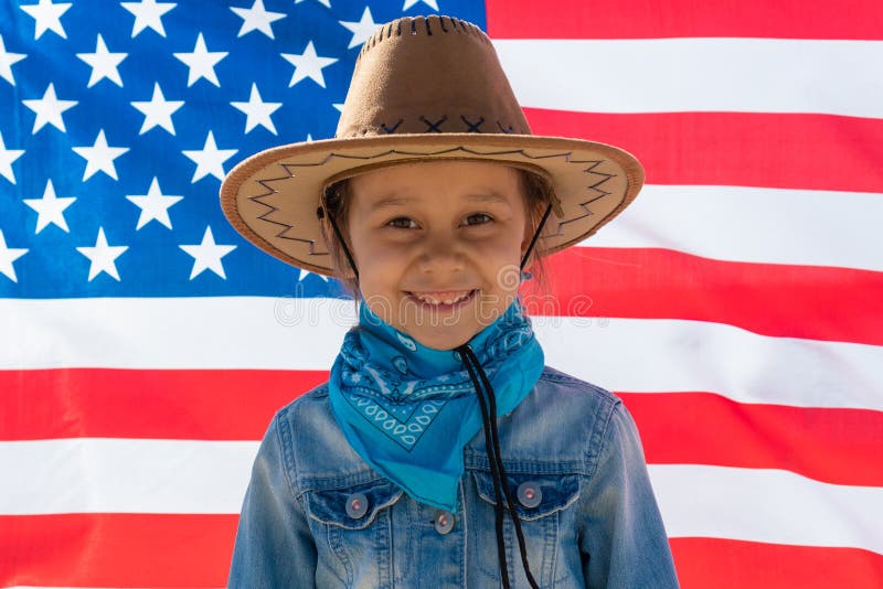 Unabh?ngigkeit Day Patriotischer Feiertag Gl?ckliches Kind, nettes kleines Kinderm?dchen mit amerikanischer Flagge cowboy stockbild Unabh?ngigkeit Day Patriotischer Feiertag Gl?ckliches Kind, nettes kleines Kinderm?dchen mit amerikanischer Flagge cowboy stockbild