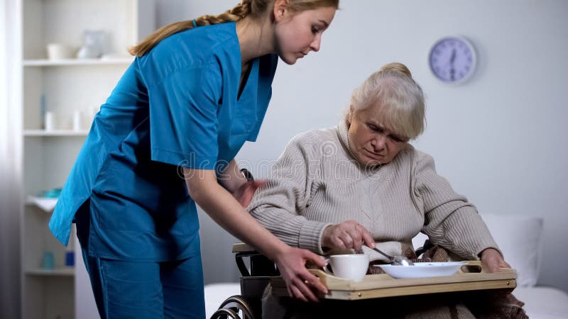 Unappetitliches Di?tabendessen der Krankenschwesterumh?llung zur alten behinderten Frau, mach's gut stockfotografie Unappetitliches Di?tabendessen der Krankenschwesterumh?llung zur alten behinderten Frau, mach's gut stockfotografie