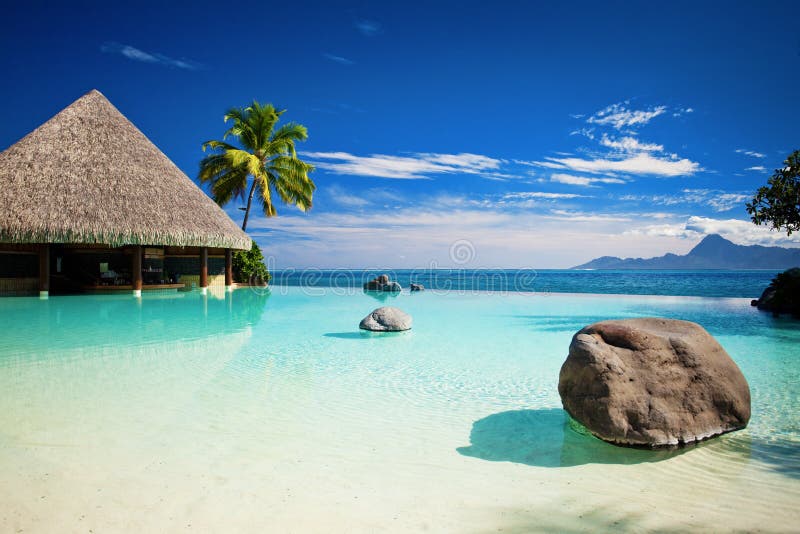 Unbegrenztheitspool mit künstlichem Strand und Ozean lizenzfreie stockbilder Unbegrenztheitspool mit künstlichem Strand und Ozean lizenzfreie stockbilder