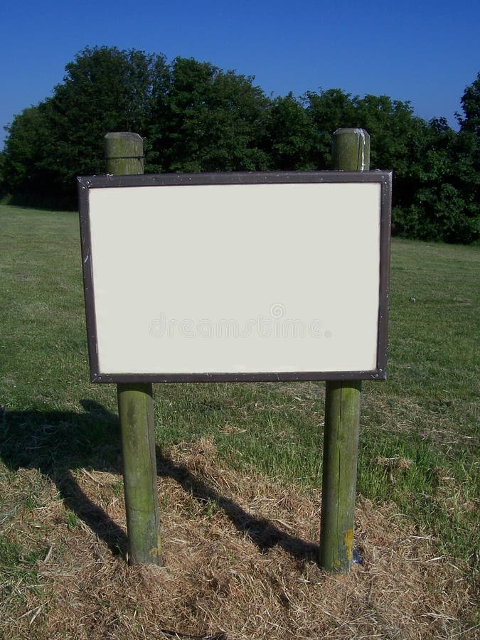 Blank horizontal sign against a green field and blue sky. Blank horizontal sign against a green field and blue sky