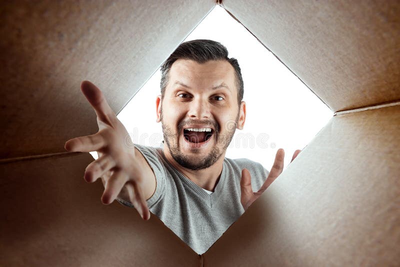 Unboxing, el fondo creativo, hombre alegre abre la caja y las miradas en sorpresa El paquete, entrega, sorpresa, regalo foto de archivo Unboxing, el fondo creativo, hombre alegre abre la caja y las miradas en sorpresa El paquete, entrega, sorpresa, regalo foto de archivo