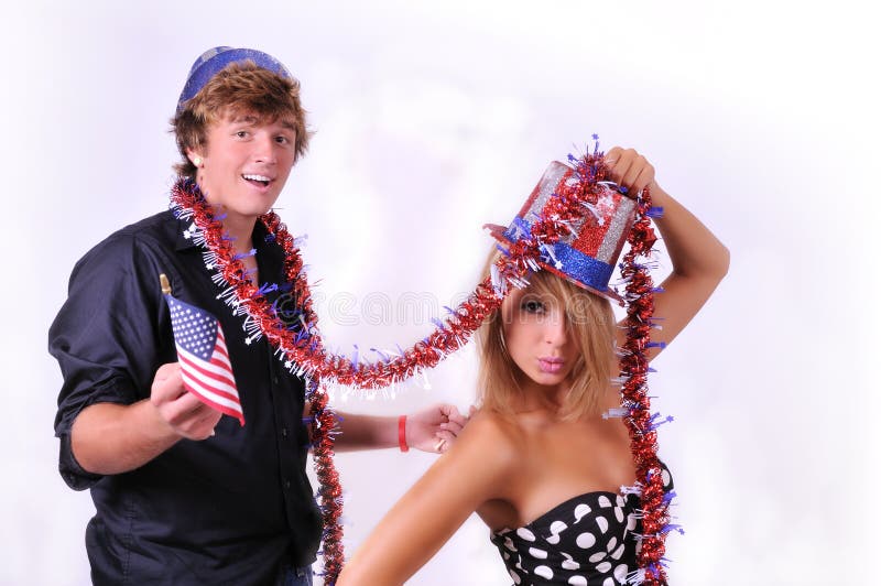 Patriotic couple dressed up with uncle Sam hats and US flag paraphanilia for the 4th of July. Patriotic couple dressed up with uncle Sam hats and US flag paraphanilia for the 4th of July