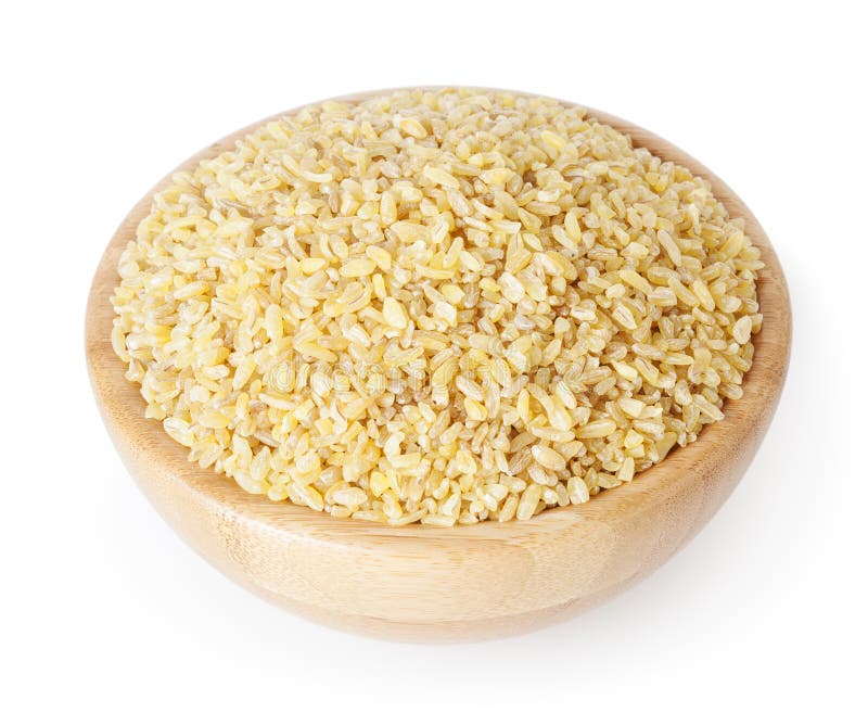 Uncooked bulgur w drewnianym pucharze odizolowywającym na bielu zdjęcie stock Uncooked bulgur w drewnianym pucharze odizolowywającym na bielu zdjęcie stock