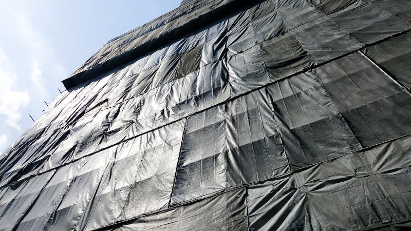 Under construction building that covered by black canvas royalty free stock photos Under construction building that covered by black canvas royalty free stock photos